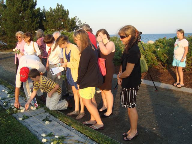 Lenihan family putting roses on Joe Lenihan's name at the Sherwood Island Memorial